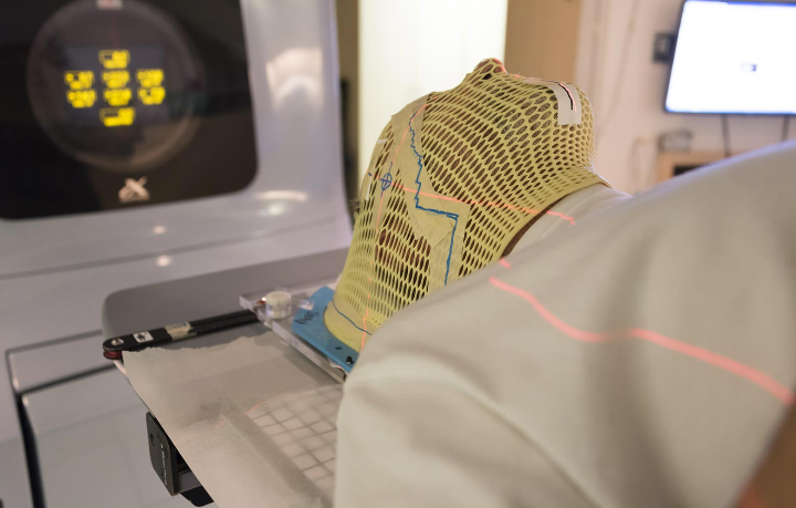 Paziente in procinto di iniziare una seduta di radioterapia, un trattamento oncologico che può causare o aggravare la disfagia.